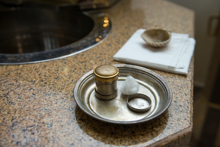 Taufe Am Rand eines Taufbeckens stehen Chrisamöl und eine Muschel für das Taufwasser.